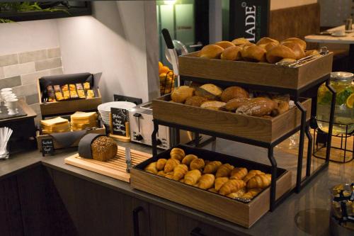 a bakery with several trays of donuts on a counter at Best Western Plus Hotel Regence in Aachen