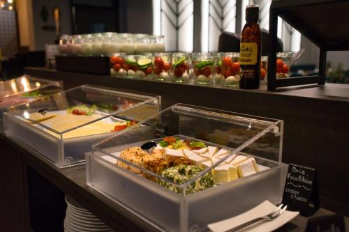 a buffet with several trays of food on a counter at Best Western Plus Hotel Regence in Aachen