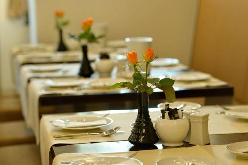 a table with a vase with orange flowers in it at Best Western Hotel Kaiserhof in Bonn