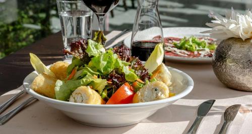 a salad in a white bowl on a table at Best Western Victor's Residenz-Hotel Rodenhof in Saarbrücken