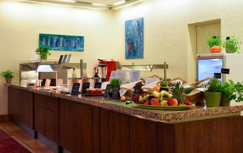 Un mostrador con una bandeja de frutas y verduras encima. en Best Western Premier Hotel Villa Stokkum, en Hanau am Main