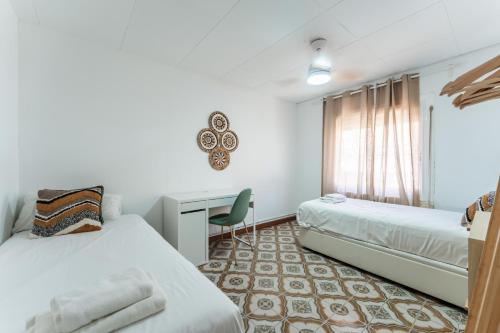 a bedroom with two beds and a desk in it at Feel Welcome Barcelona 10 in Cornellà de Llobregat
