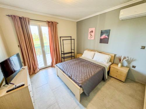 a bedroom with a bed and a flat screen tv at Beachlife: The Bungalow in Kos