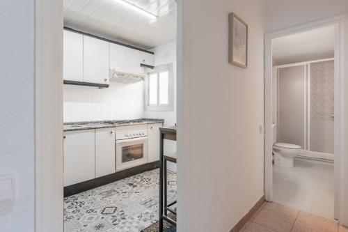 a white kitchen with a sink and a toilet at Feel Welcome Barcelona 10 in Cornellà de Llobregat