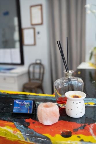 a table with a drink and a bowl of liquid and a candle at Hotel Caribe in Casalnuovo di Napoli