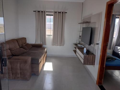 a living room with a couch and a television at Rancho Bela Vista - Corumbá IV in Alexânia