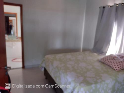 a bedroom with a bed with a curtain and a window at Rancho Bela Vista - Corumbá IV in Alexânia