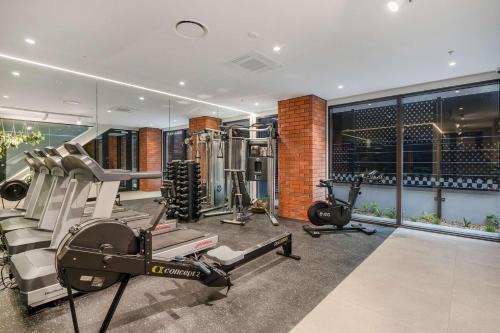 a fitness room with a gym with tread machines at The Courtenay Chic Retreat 1BR Apartment in Wellington