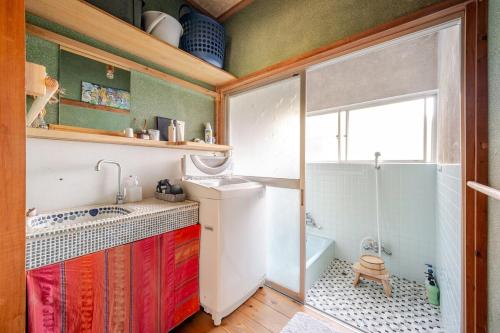 a bathroom with a shower and a sink and a toilet at 新緑の南伊豆焚き火の宿ノキロ in Minamiizu
