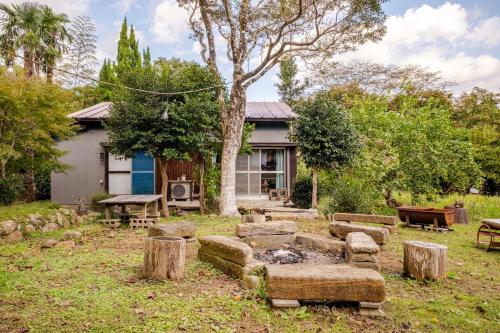 a house with a fire pit in a yard at 新緑の南伊豆焚き火の宿ノキロ in Minamiizu