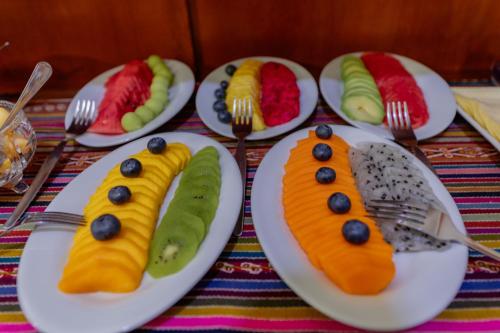 a table topped with plates with fruit on them at Dreams Boutique Hotel Cusco in Cusco