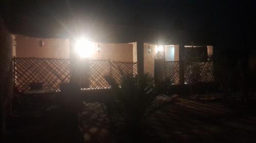 a light on the side of a house at night at Dar Tamzdamte Skoura in Skoura