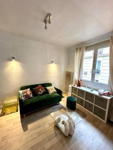 un salon avec un canapé vert et une table dans l'établissement Studio Étoile - Champs Élysées, à Paris