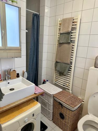 une salle de bain avec un lavabo et une machine à laver dans l'établissement Studio Étoile - Champs Élysées, à Paris