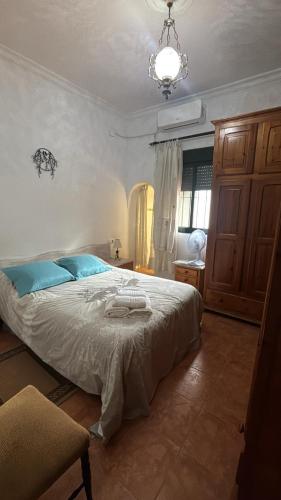 a bedroom with a large bed with blue pillows at ALBORADA TRES in Burguillos