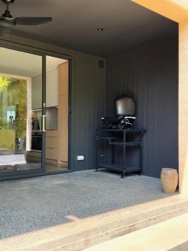 a screened in porch with a view of a kitchen at Riverbank House in Mudgee