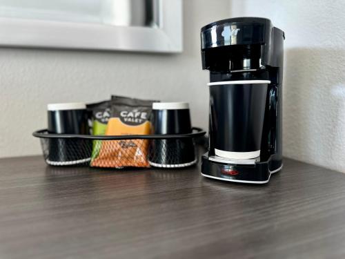 a coffee maker sitting on a counter with two cups at Summerfield Inn Fresno Yosemite in Fresno