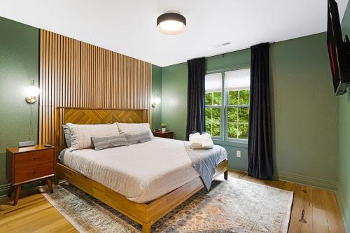 a bedroom with a bed with green walls and a window at Luxury Escape! Golf Sim, Sauna, Hot Tub & Game Room Bliss in Fairview