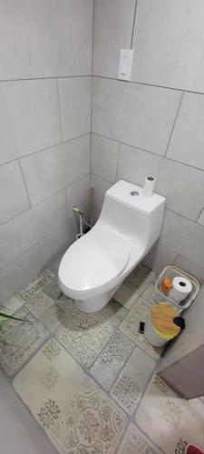 a bathroom with a white toilet in a room at The Red Door Beach House, Buye Beach in Cabo Rojo