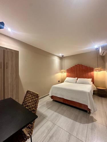 a bedroom with a bed and a table and chairs at Hotel Londres in Valledupar