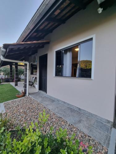 a white house with a window and a patio at Frieden Haus Hospedagem in Pomerode