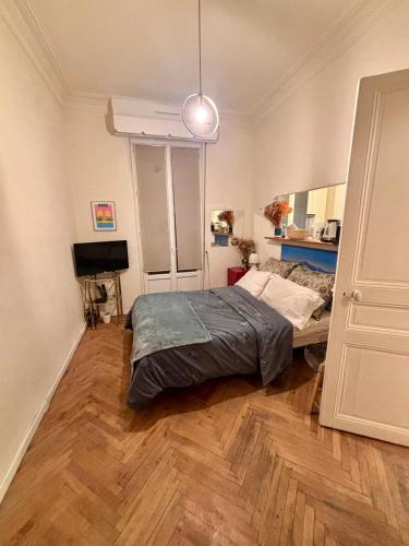 - une chambre avec un lit sur du parquet dans l'établissement Appartement Nice centre ville gare, à Nice