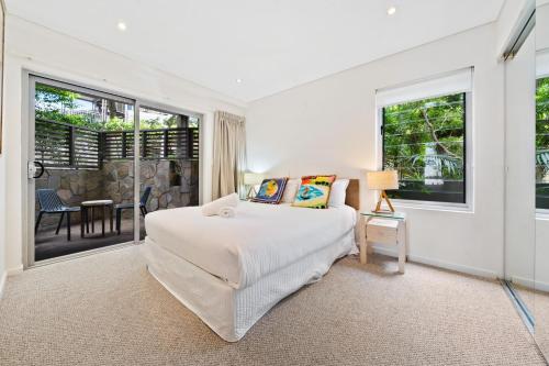 Un dormitorio con una cama y grandes ventanales. en Waves #1 by Discover Stradbroke, en Point Lookout
