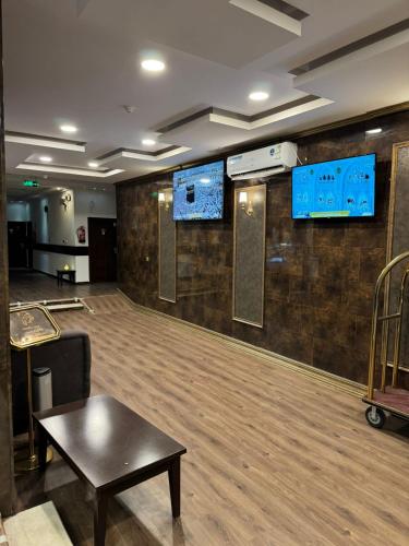 a empty dance floor with two monitors on the wall at Oroub El Forssan in Buraydah