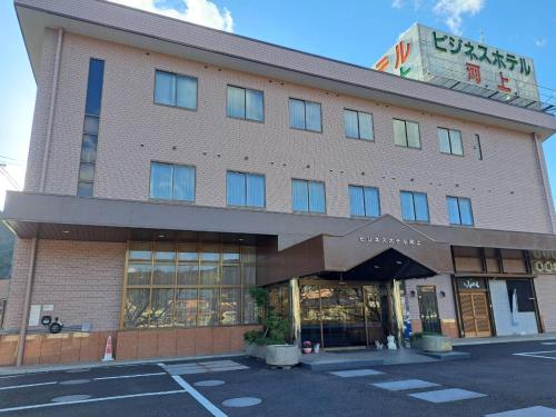 a building with a sign on the top of it at Business Hotel Kawakami in Kumano