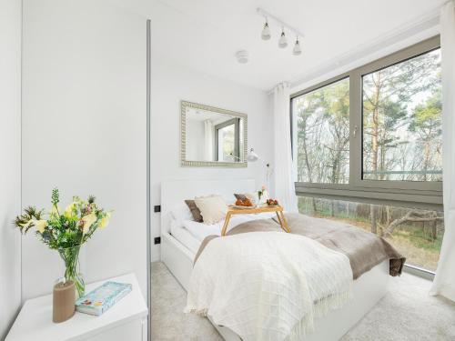a white bedroom with a bed and a window at Apartment in Pobierowo with Sea View in Pobierowo