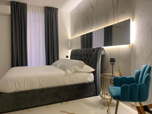 a bedroom with a bed and a blue chair at Bellini Luxury Suite Superior in Catania