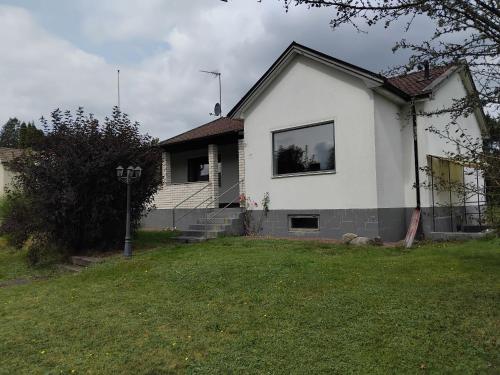 a white house with a window in a yard at Relax Villa in Sibbhult