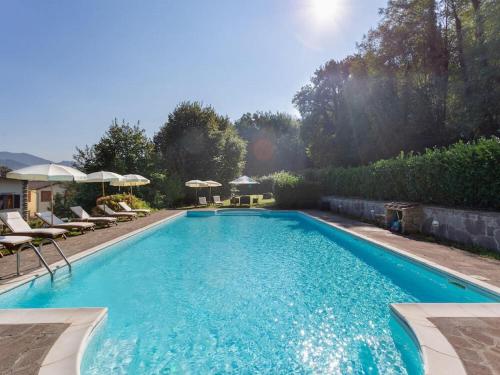 a large blue swimming pool with chairs and umbrellas at Villa in Mugello Hills with Private Pool in Vicchio