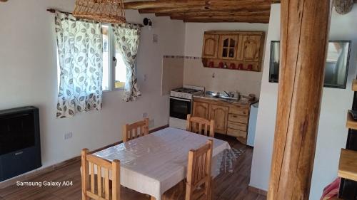 a kitchen with a table and chairs in a room at Alojamiento Küme Kiyen in Aluminé