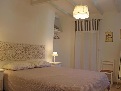 une chambre avec un lit et un lustre dans l'établissement Les Platanes, à LʼIsle-sur-la-Sorgue