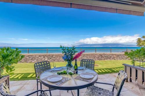 a table with chairs and a view of the ocean at A9 Direct Oceanfront 2 Level 2 Lanai Amazing Views Sunsets & AC Comfort in Lahaina