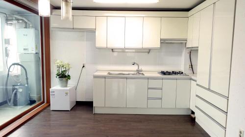 a kitchen with white cabinets and a sink at Happy Memory in Jeonju