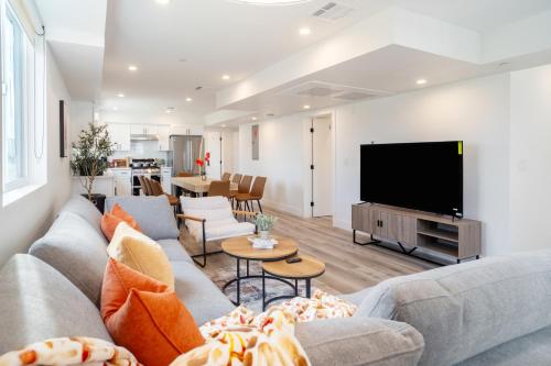 a living room with a couch and a flat screen tv at Urban Oasis in the Heart of LA Near USC & Major Attractions in Los Angeles