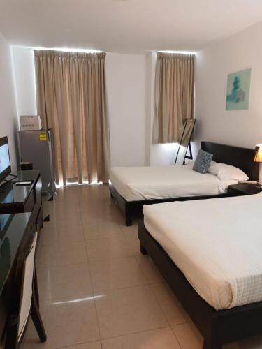 a hotel room with two beds and a television at Playa Blanca SC in Río Hato
