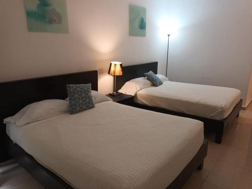 a room with two beds and a lamp in it at Playa Blanca SC in Río Hato