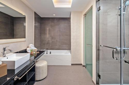 Un baño con bañera, lavabo y ducha. en Scarlet Pearl Casino Resort, en Biloxi