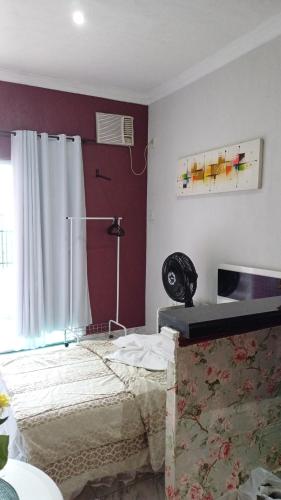 una camera da letto con un letto, una scrivania e una finestra di Loft Amazônia a Belém