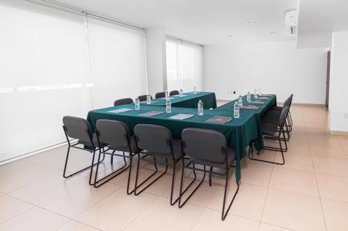 a conference room with a green table and chairs at Hotel México Plaza Silao Aeropuerto in Silao