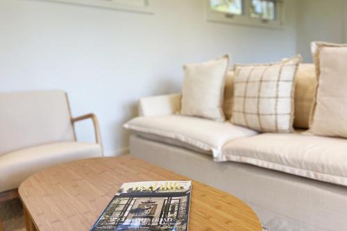 a living room with a couch and a coffee table at Beautiful garden cottage in Bowral in Bowral