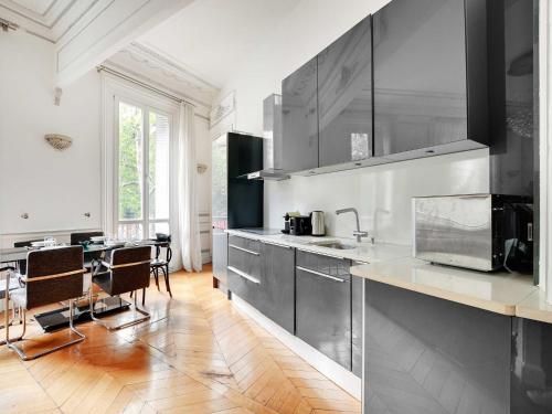 une cuisine avec des appareils en acier inoxydable et une table dans l'établissement Magnificent Appt - 2BD 4P - Champs-Élysées Alma, à Paris