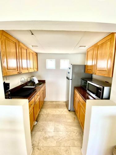 a kitchen with wooden cabinets and a stainless steel refrigerator at Condos Privados en Huatulco in Tangolunda