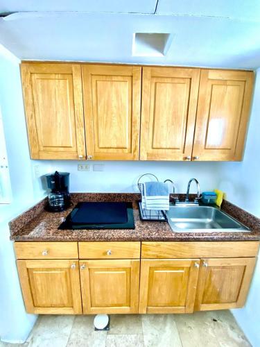 a kitchen with wooden cabinets and a sink at Condos Privados en Huatulco in Tangolunda