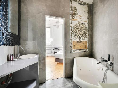 une salle de bain avec une baignoire et un lavabo et une baignoire dans l'établissement Magnificent Appt - 2BD 4P - Champs-Élysées Alma, à Paris