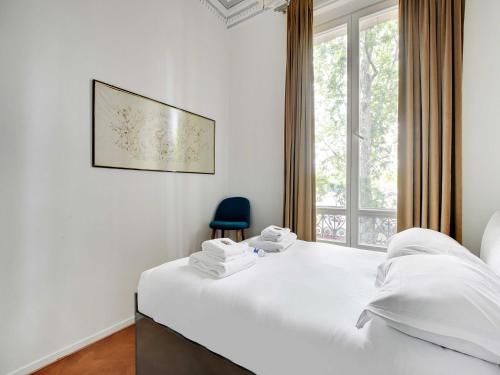 une chambre avec un lit blanc et une chaise bleue dans l'établissement Magnificent Appt - 2BD 4P - Champs-Élysées Alma, à Paris