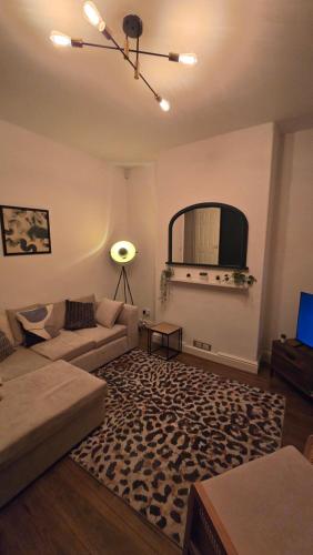 a living room with a couch and a tv at Cosy 3 Bedroom, 5 Bed House! in Headingley
